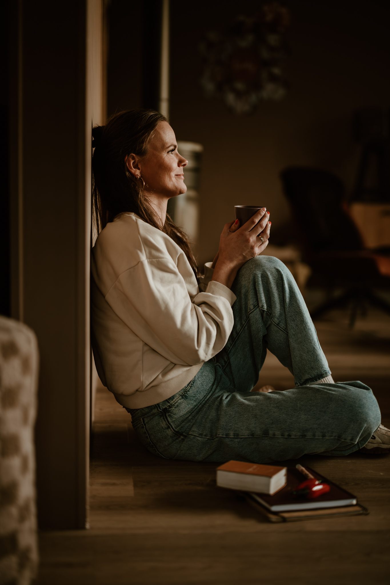 Margriet in gedachten met een kop koffie en haar Bijbel binnen handbereik